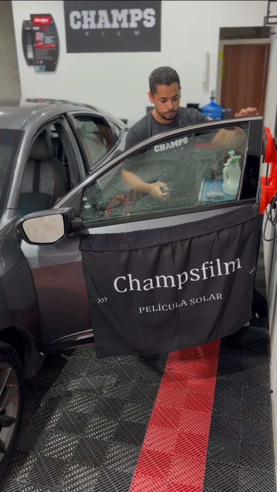 Técnico da Champs Film aplicando película com precisão e cuidado profissional